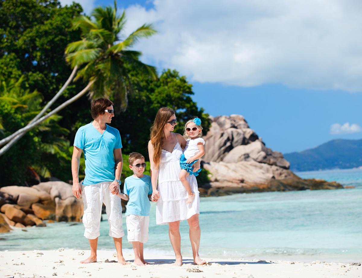 Portrait of happy young family with two kids on tropical vacation